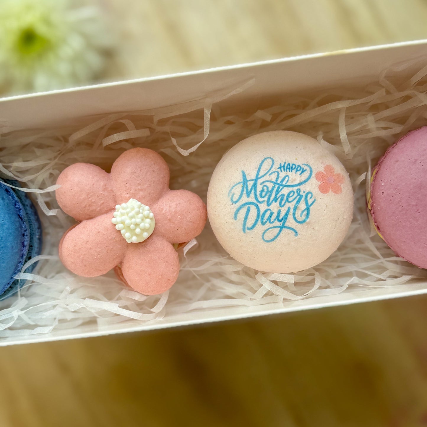 Macarons with 'Happy Mother's Day' text and a flower design in a box.